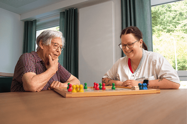 Spielenachmittag Bernhard-Salzmann-Haus Pflegefachkraft spielt gemeinsam mit Seniorin ein Brettspiel. Szene: DRK Soziale Dienste Meschede